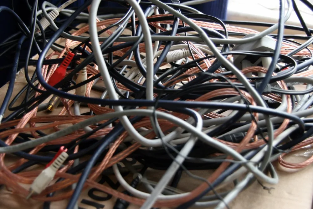 A dense bundle of patch cables behind a network switch.